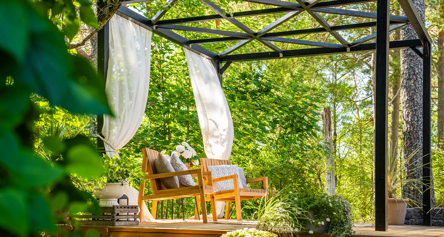 Moderni pergola terassilla. Oleskelualue, pergola ja puutarhatuolit.