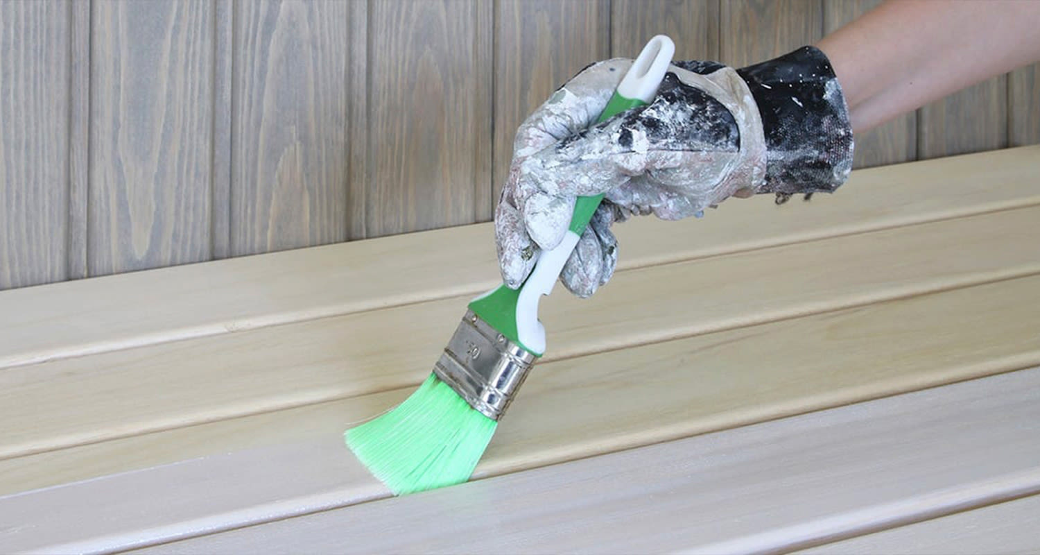 Saunan lauteiden käsittely onnistuu saunavahalla tai parafiiniöljyllä. Kuvassa Supi Laudesuojaa levitetään lauteisiin.