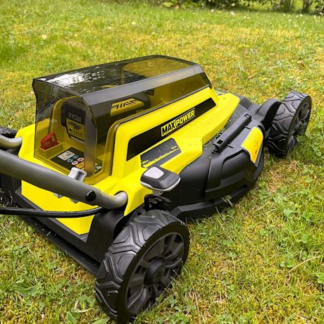 Tuotetestissä Ryobin akkuruohonleikkuri RY36LMM46A-140 ja lähikuvassa pihamaalla valmiina hommiin