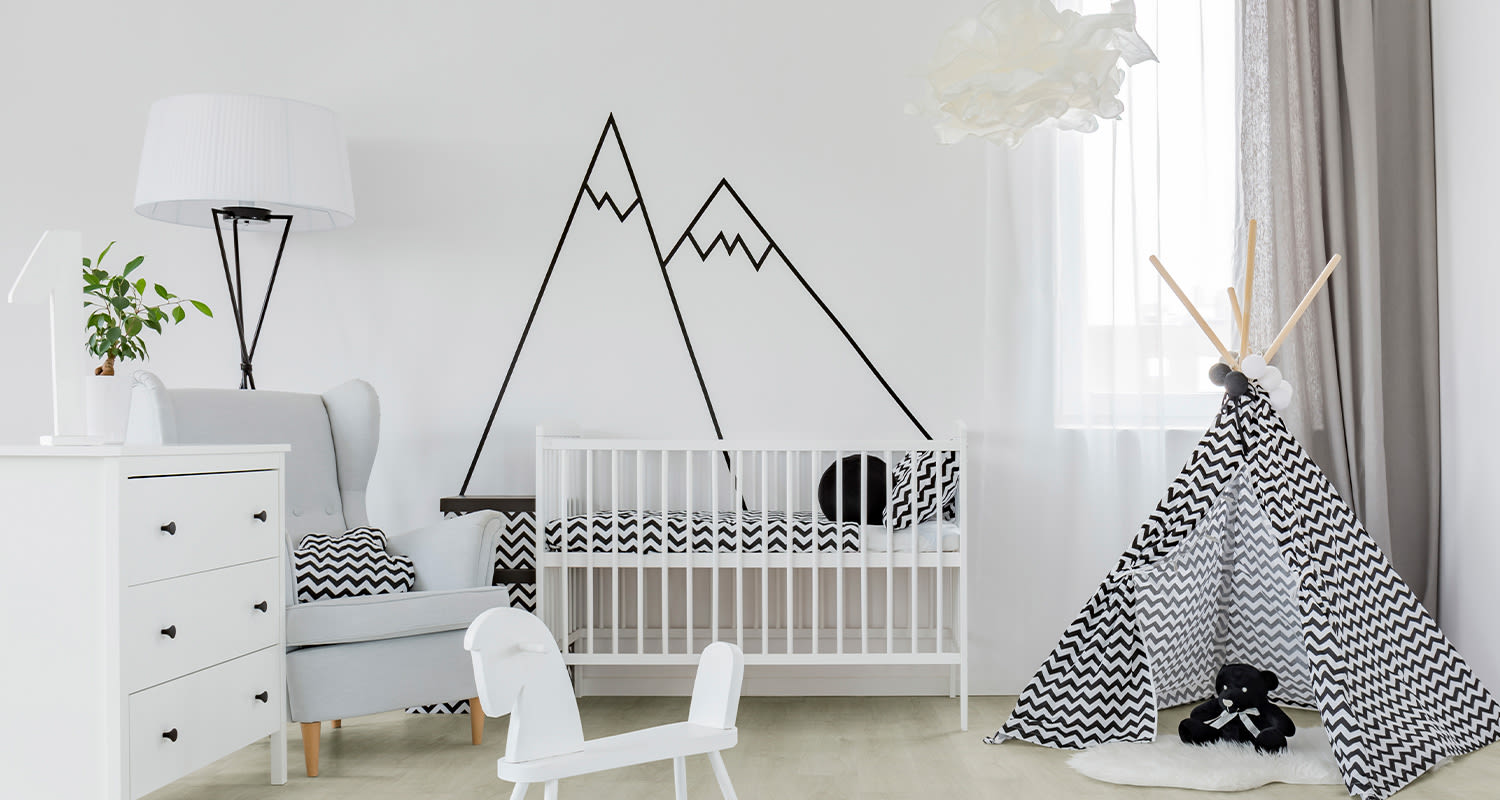 Vaalea lastenhuone: valkoinen pinnasänky, musta vuoripiirros, harmaa nojatuoli, siksak-teepee