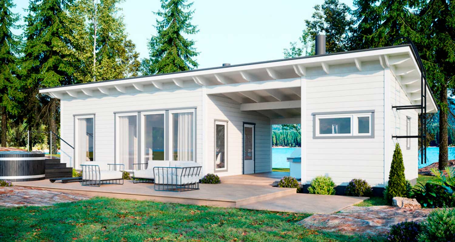 Valkoinen mökki järven rannalla, puuterassi ulkokalusteilla ja havumetsä taustalla