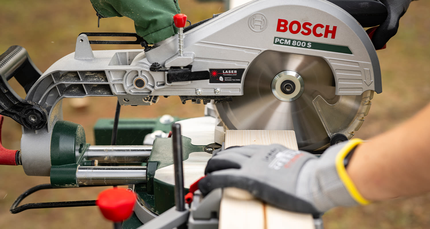 Tee itse terassikaide: Mies sahaa pystypuita