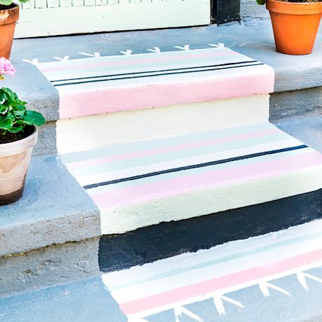 Pastelliraidalliset raput ja kukkaruukkuja talon edessä.