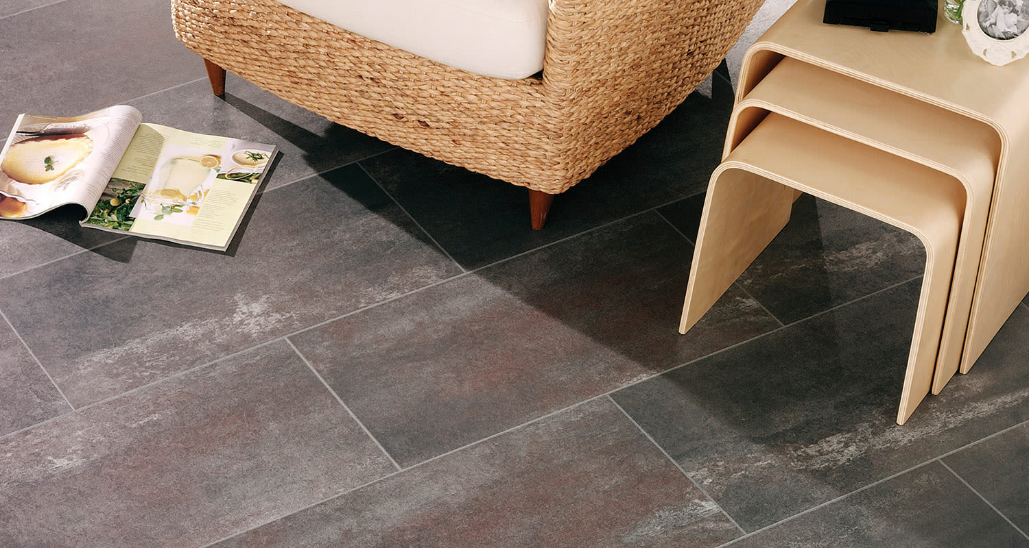 Tumma laattatyylinen laminaattilattia ja punosnojatuoli