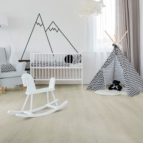 Lastenhuone: vaalea lattia, valkoinen kehto ja keinu, mustavalkoinen zigzag-teepii.