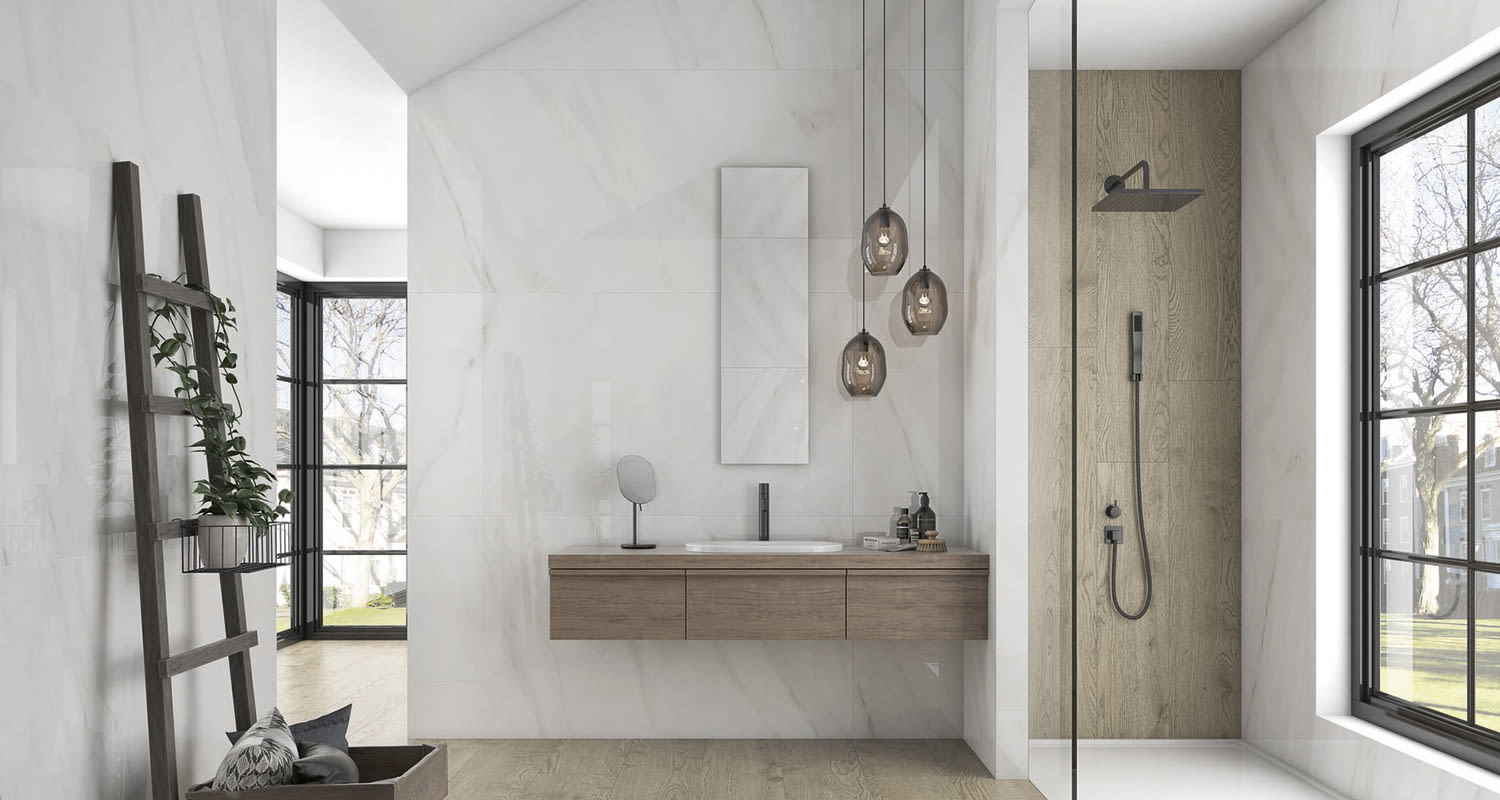 Valkoinen kylpyhuone: puinen kelluva allaskaappi, kolme lasivalaisinta, suihku ikkunan vieressä.