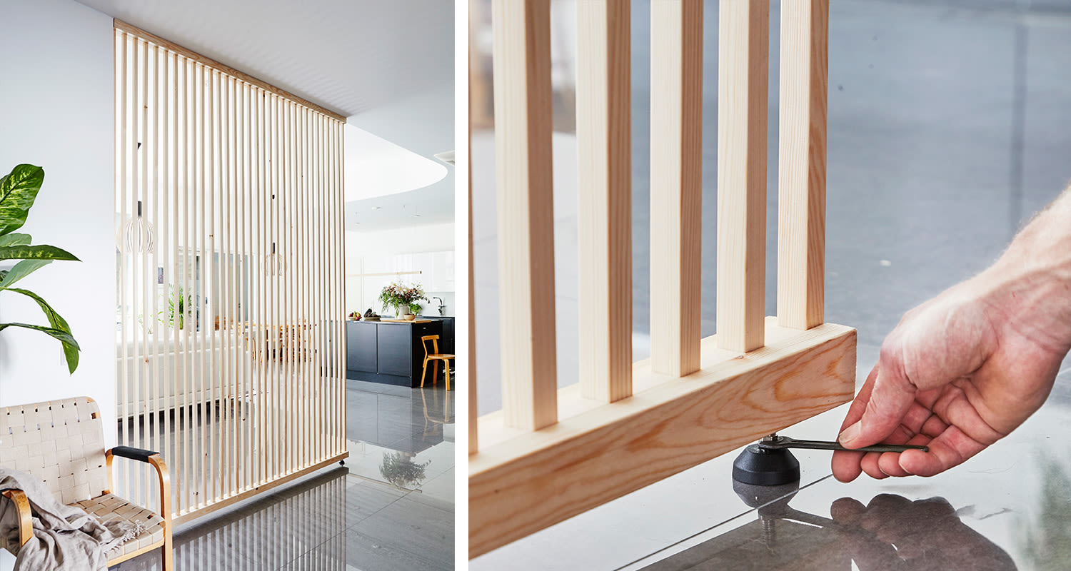 Vaalea puinen rullallinen tilanjakaja valoisassa modernissa kodissa, käsi säätää jalkaa.