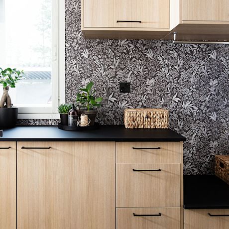 Remontoitu kodinhoitohuone ja puiset vaaleat kaapit