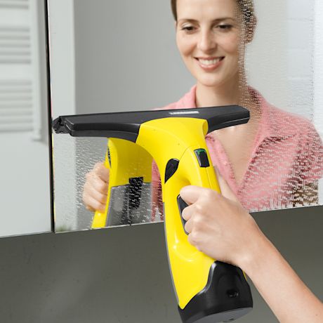 Keltamusta ikkunankuivain pyyhkii vesiroiskeet peilistä, taustalla pinkki paita.