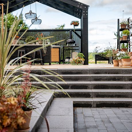 Tummat kiviportaat sekä tumma kesäkeittiö.