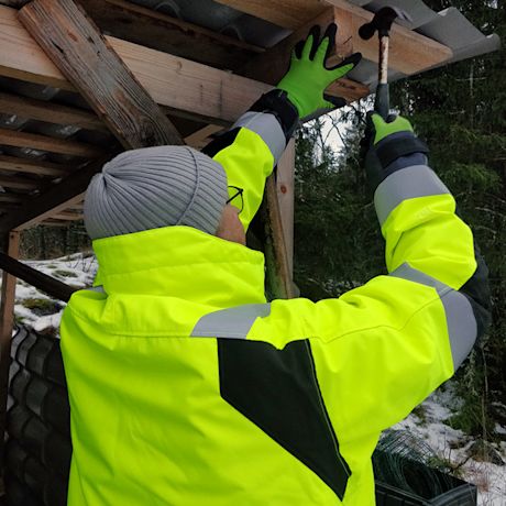 Snickersin keltainen huomiotalvitakki ammattilaisen päällä, myynnissä K-Raudassa