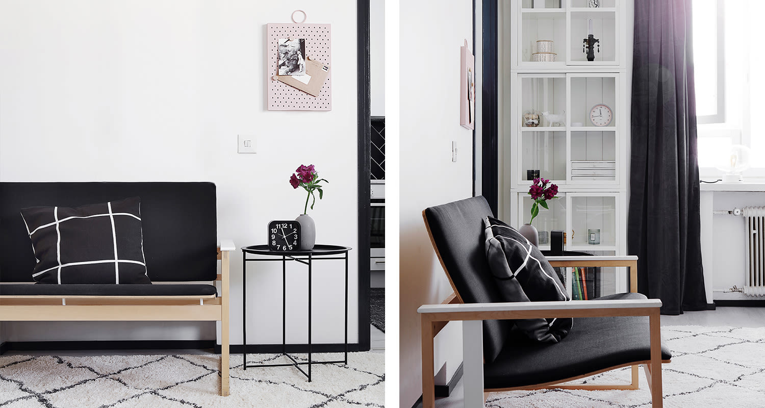 Skandinaavinen olohuone: vaalea puupenkki mustalla ruudullisella tyynyllä, sivupöytä purppurakukilla