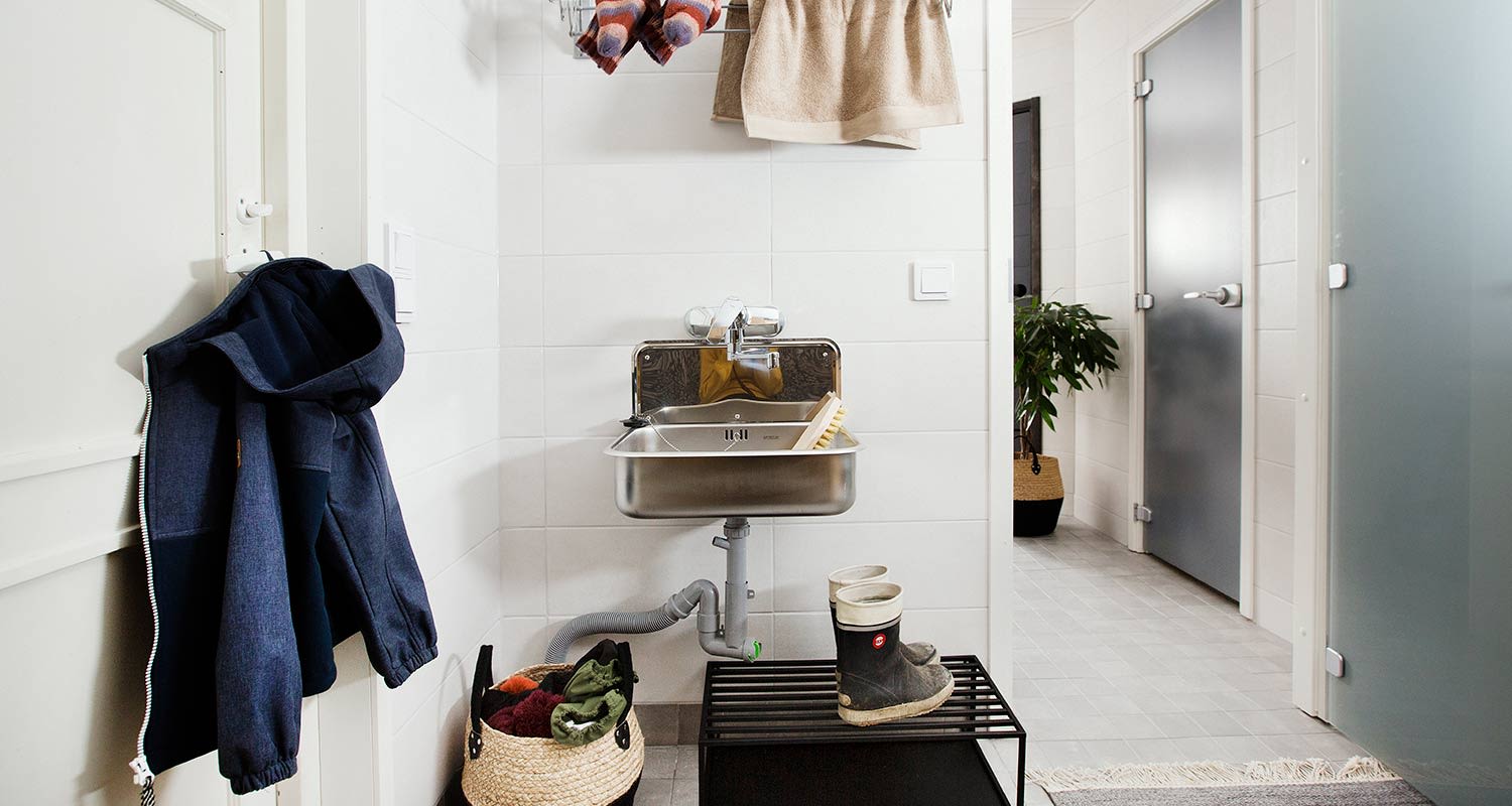 Kodinhoitohuoneen eteistila vaaleilla laatoilla