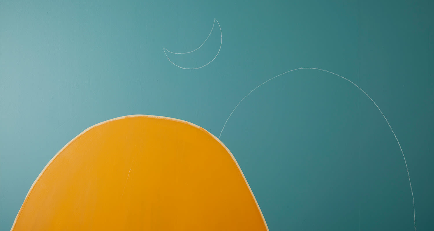 Turkoosilla taustaseinällä oranssi kaareva muoto ja valkoiset liituviivat, liidulla piirretty puolikuu