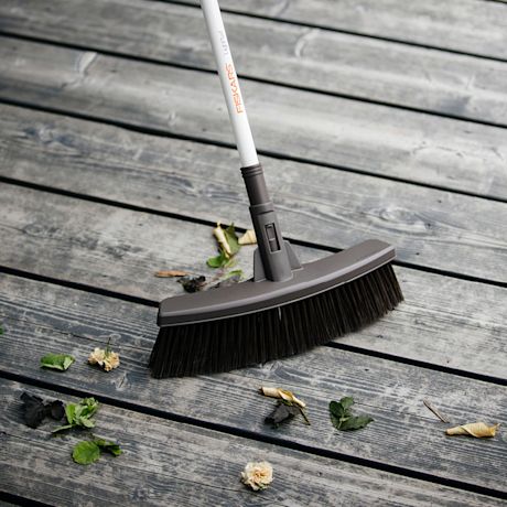 Harmaalla terassilla Fiskars-harja pyyhkii vihreitä ja ruskeita lehtiä