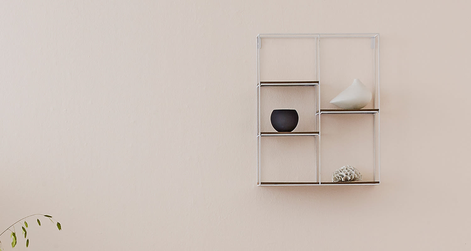 Cellon vaalea kevyennäköinen seinähylly puuterin värisellä seinällä.
