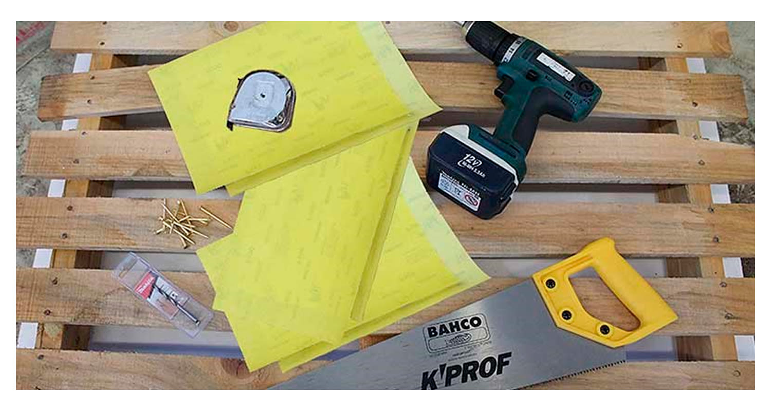 Puulavalla keltaisia muovilevyjä, vihertävä porakone, saha, mittanauha ja nauloja