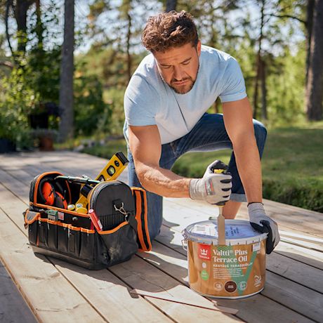 Mies avaa terassiöljypurkkia.
