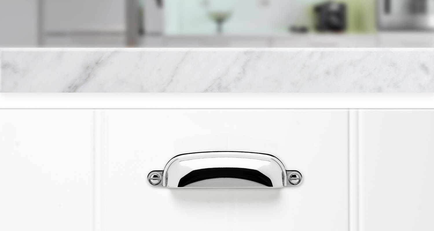 Teräksen värinen vedin valkoisessa keittiökaapissa