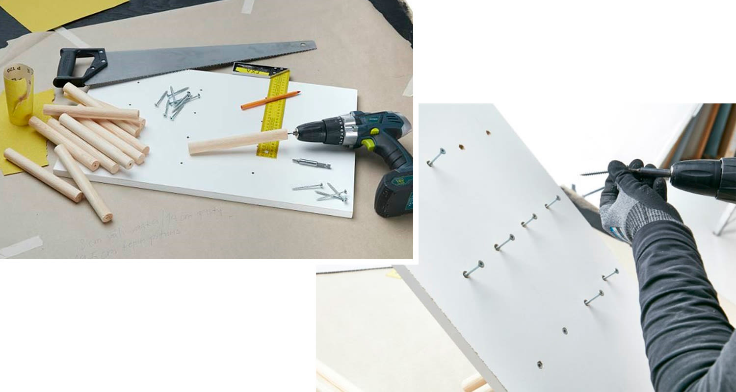 Työpöydällä valkoinen levy, puutapit, ruuvit, porakone ja käsineellinen poraava käsi.