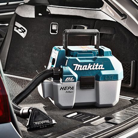 Turkoosi-harmaa Makita HEPA-pölynimuri auton takakontissa