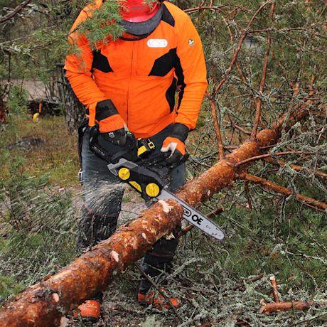 mies sahaa puuta FXA-moottorisahalla