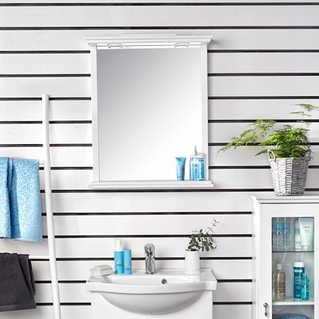 Valkoinen kylpyhuone raidallisella seinällä, peilikaappi, siniset pyyhkeet ja purkit, vihreä kasvi