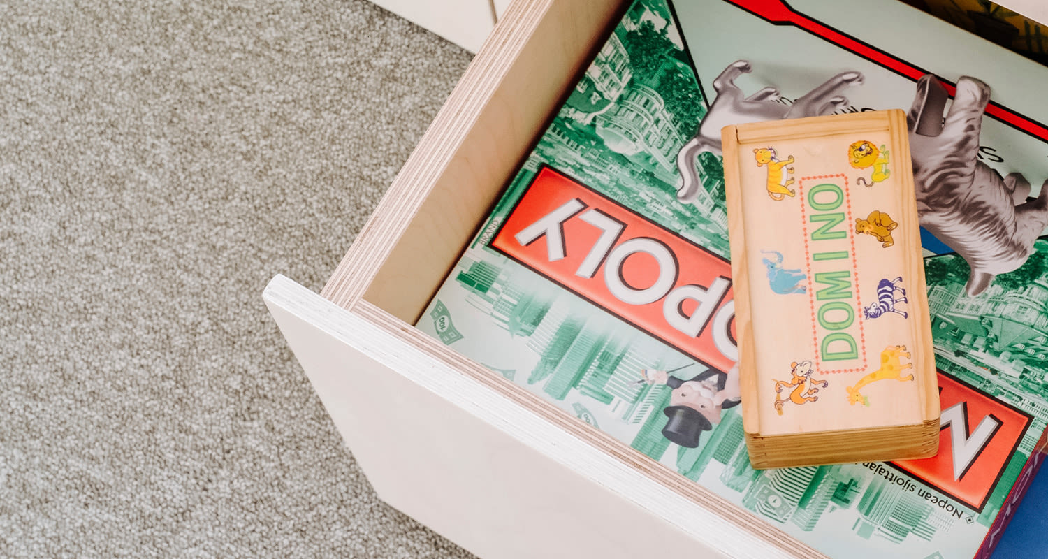 Korotetun alkovin laatikosto, josta näkyy Monopoly ja muita lautapelejä.