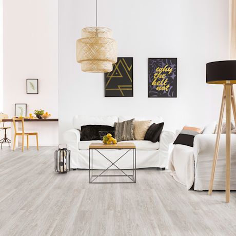 Vaalea skandinaavinen olohuone: valkoinen sohva, musta-keltaiset taulut, rottinkivalaisin