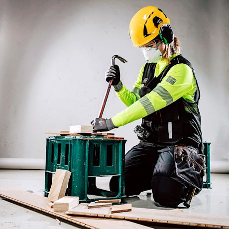 Nainen tekee remonttihommia suojavaatteissa