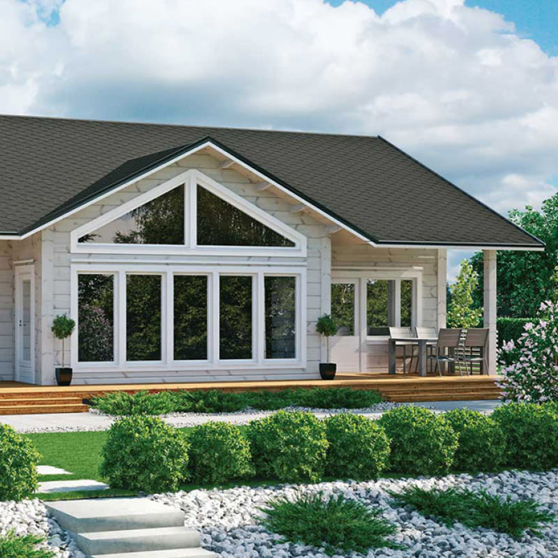 Valkoinen hirsimökki mustalla katolla, isot ikkunat ja puuterassi vihreiden pensaiden edessä