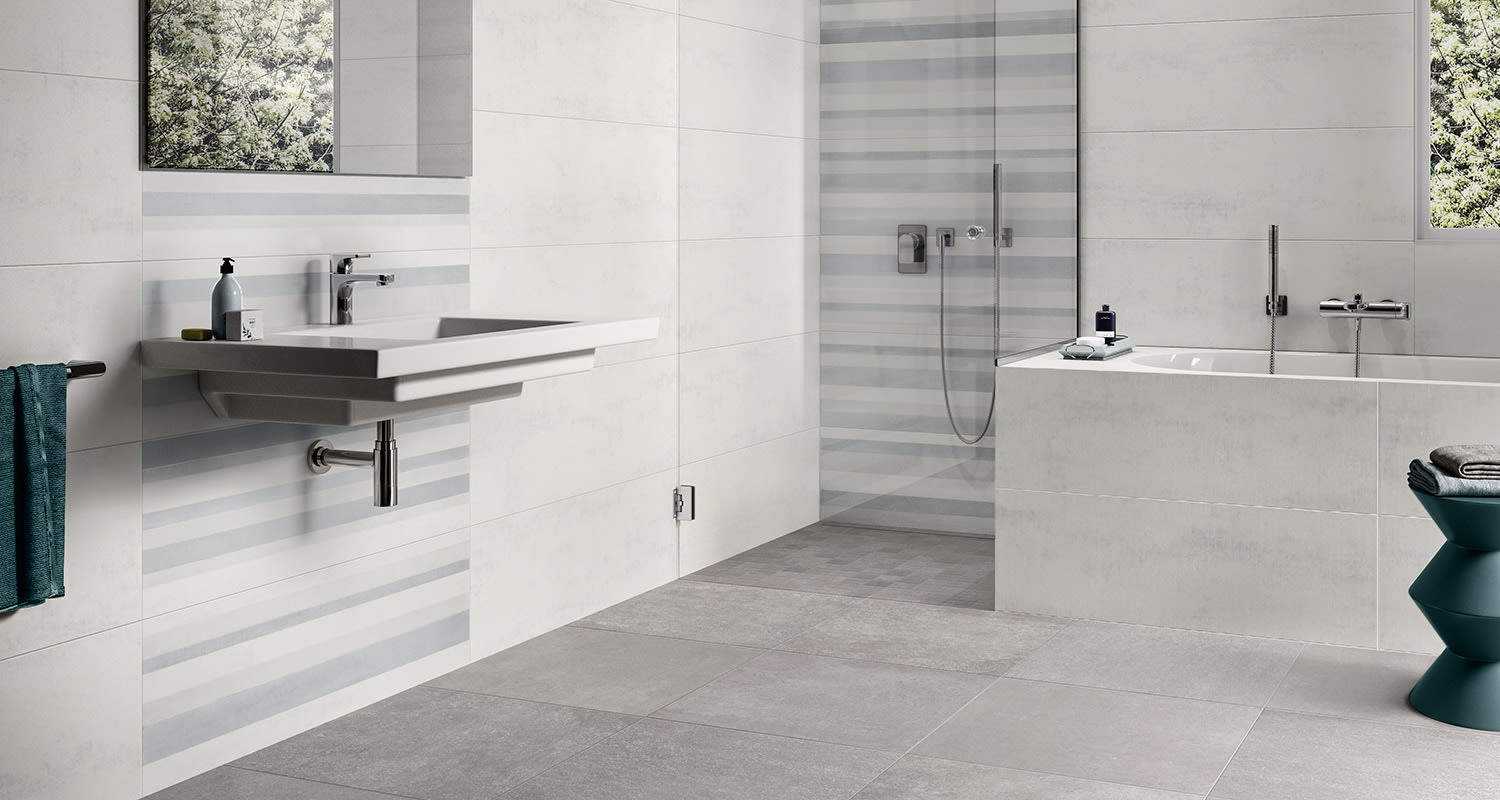 Vaalea kylpyhuone, jossa harmaat lattialaatat ja vaaleat vaakamalliset seinälaatat