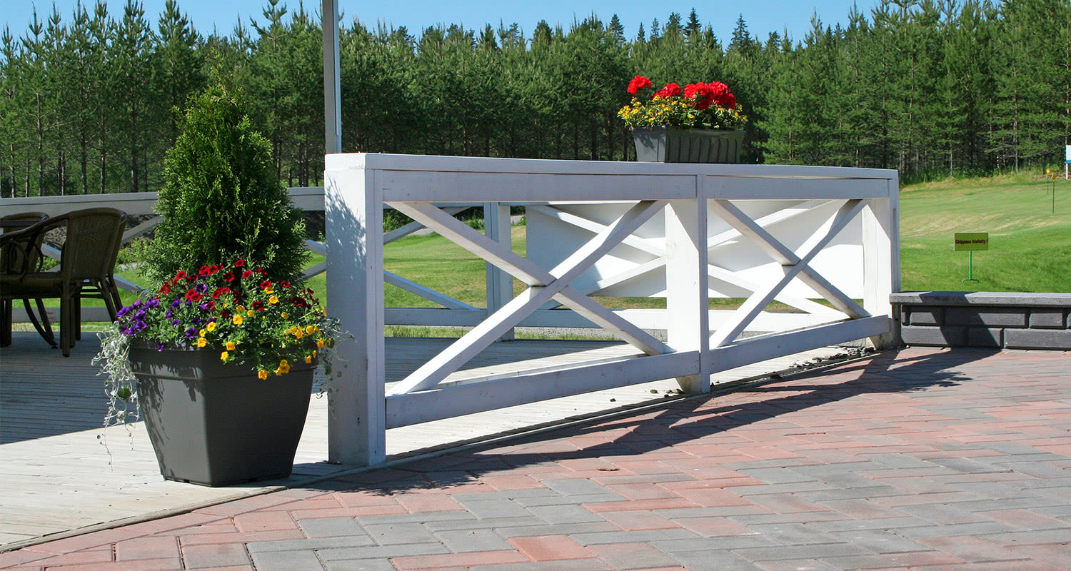 Pihalaatoista rakennettu mökkipiha kesäisessä säässä.