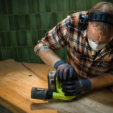 Mies hioo kylpyhuoneeseen puista pesupöytää