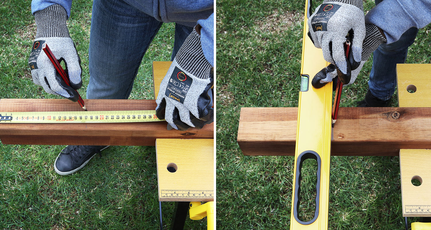 Suojakäsineinen käsi mittaa ja merkitsee ruskeaa puupalkkia keltaisella vaaitustasolla