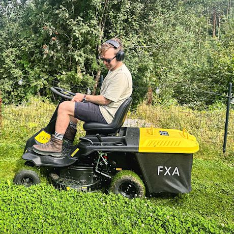 Testissä pihamaalla FXA D225 -ajoleikkuri ja 3M WorkTunes Connect Solar -kuulosuojaimet