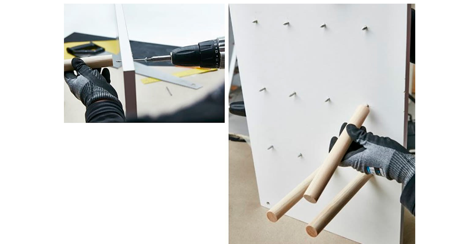 Mustakäsineinen käsi poraa ja asettaa puutappeja rei'itettyyn valkoiseen paneeliin.