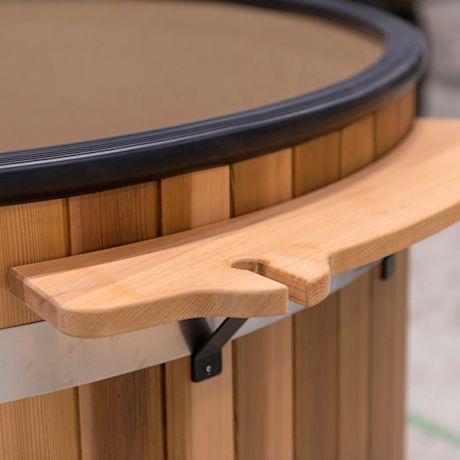 Kuusipuisen paljun musta reunus ja kiinnitetty vaalea puinen istuintaso.