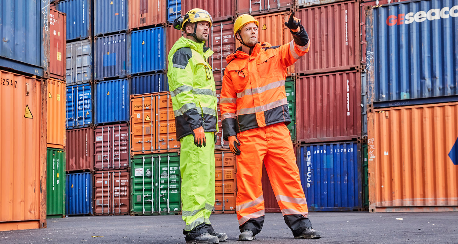 Työmiehet konttien edustalla K-Raudan PROF-huomiotyövaatteissa