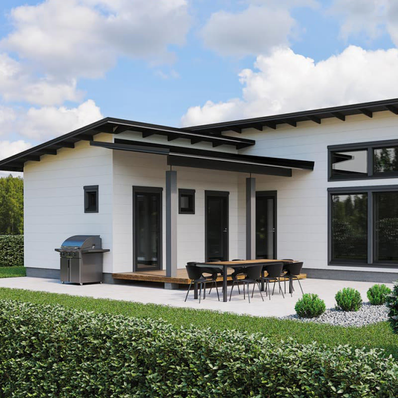 Moderni valkoinen talo mustilla kehyksillä, terassilla ruokapöytä, grilli ja vihreä piha.