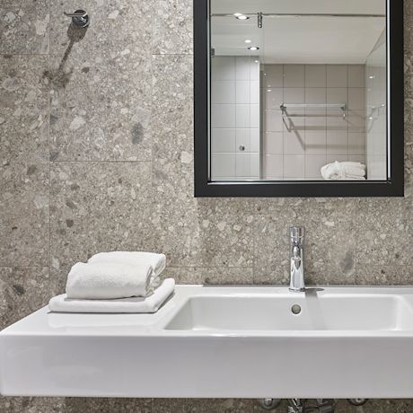 Hotelli Scandic Lahti Cityn maanläheisillä sävyillä uudistut kylpyhuoneet, joista löytyy Keskon valikoiman laattoja.