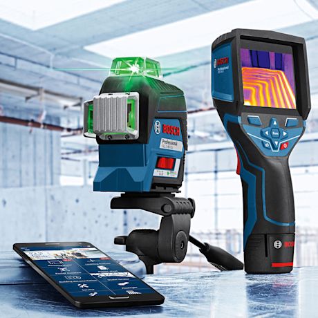 Rakennustilassa Boschin sinimusta laserlevelin vihreällä linjalla, lämpökamera ja puhelin.