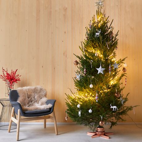 Kuvassa joulukuusi puisessa sisustuksessa. Joulukuusessa valot ja koristeet.