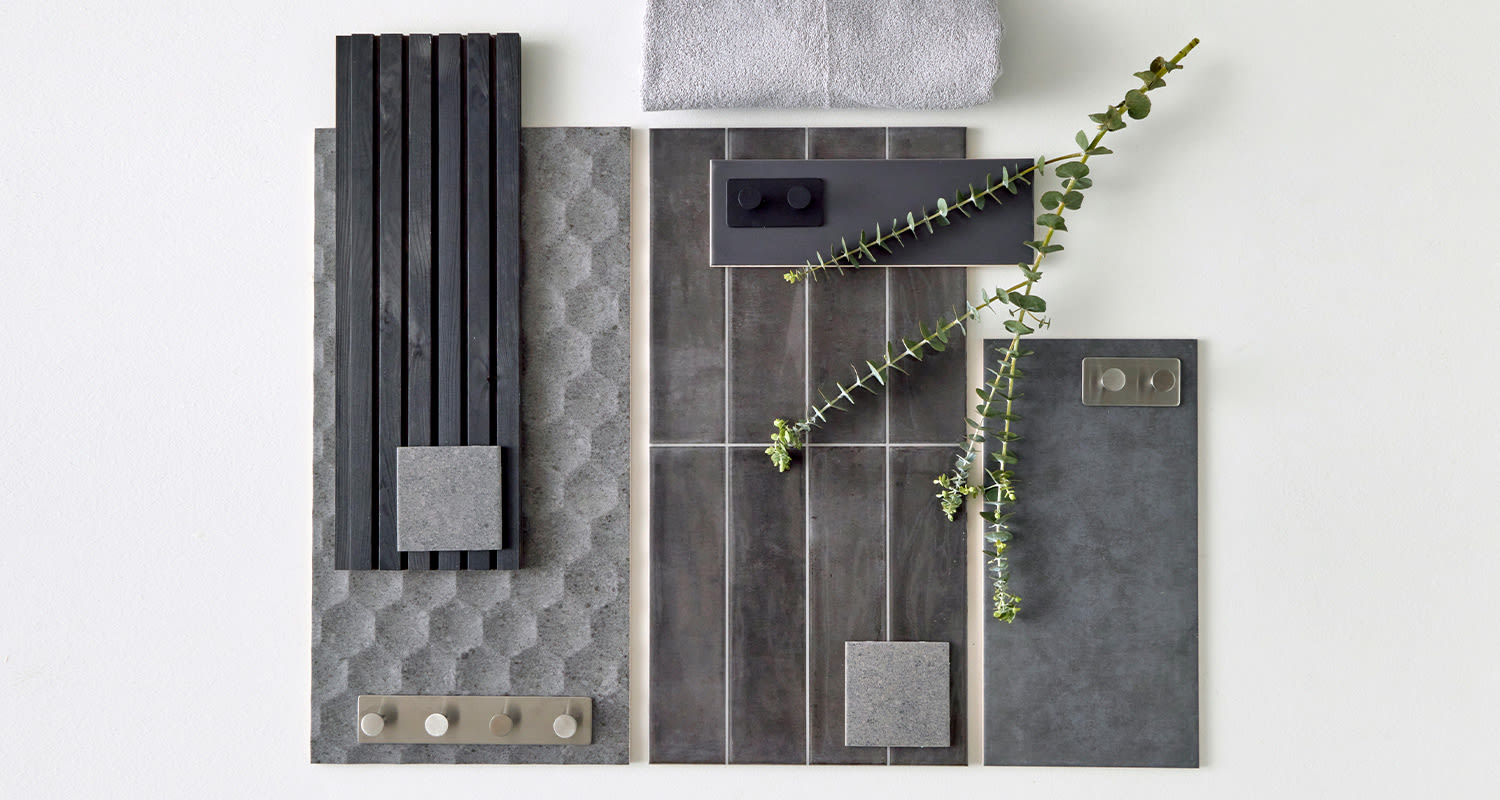 Kuvassa erilaisia tummia kylpyhuoneen pintamateriaaleja. Kylpyhuonetrendeissä korostuu vuonna 2024 tummat ja vaaleat kokonaisuudet.