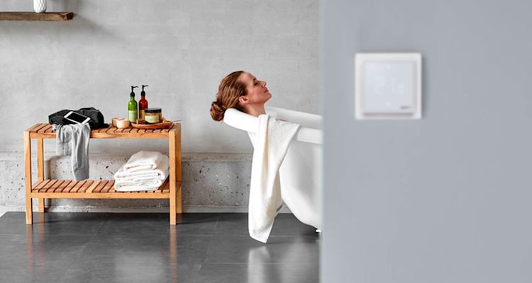 Moderni harmaa kylpyhuone, valkoinen amme, puinen penkki saippuoineen ja pyyhkeineen