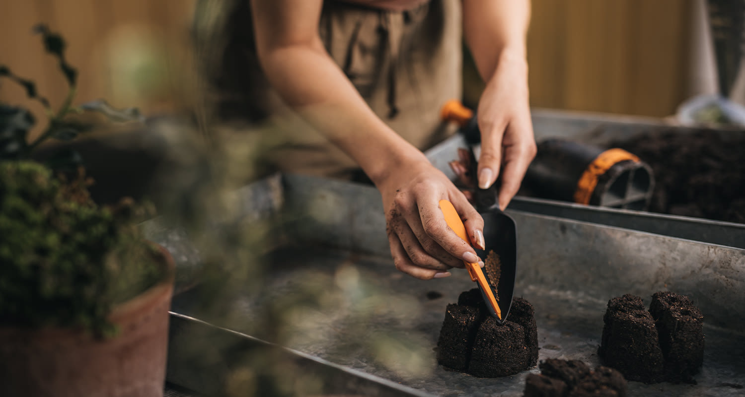 Nainen tekemässä kevätistutuksia.