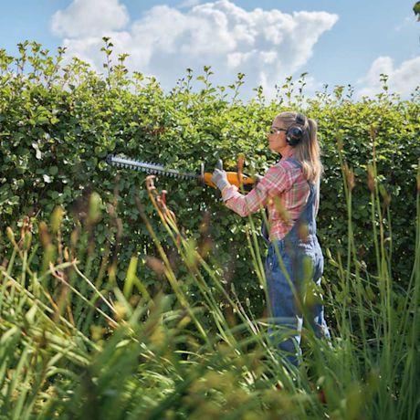 Nainen käyttää puutarhakonetta.