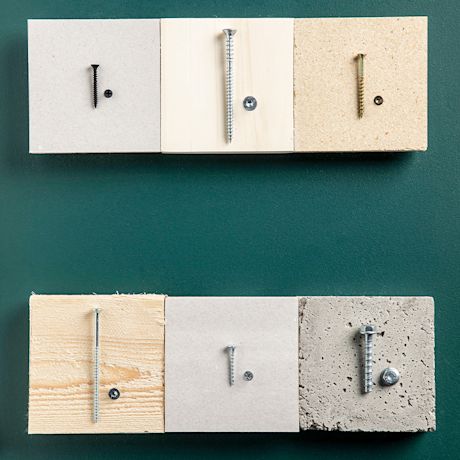 Kuusi erikokoista ruuvia kiinnitettynä levyihin (puu, lastu-, kipsi-, betoni) vihreällä taustalla