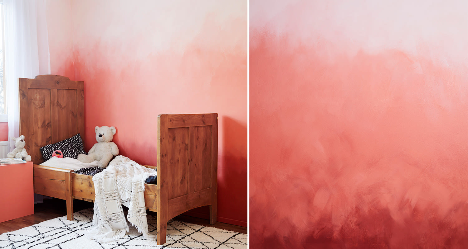 Lapsen puusänky nallen ja virkatulla peitolla koralli-vaaleanpunaisella ombre-seinällä