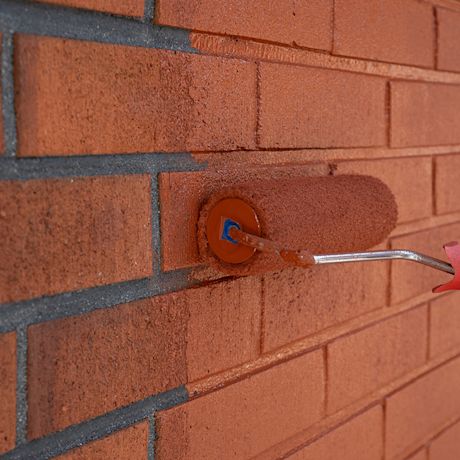 Tiilitaloseinän maalaus käynnissä Tikkurila Kivitex Brick House Paint -tiilitalomaalilla. Tuotetta myy K-Rauta, saatavissa eri pakkauskoossa.